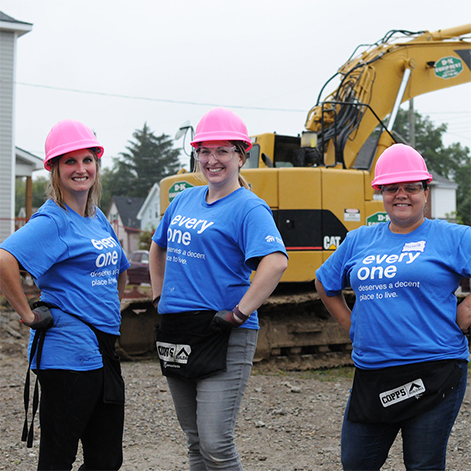 Female employees posing while working with Habitat for Humanity partnership.