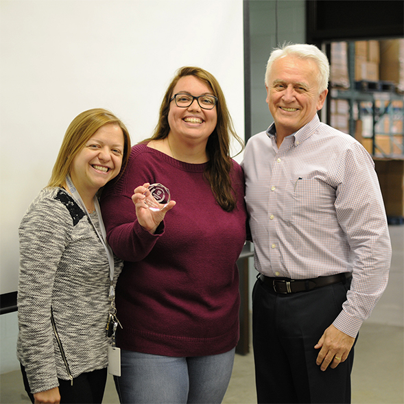 Brad with employee and manager with holding the award.