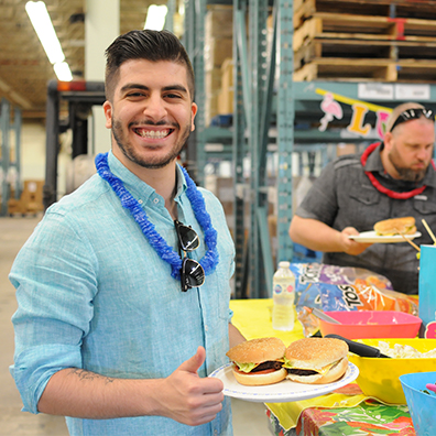 An employee smiling with food plate in hand.